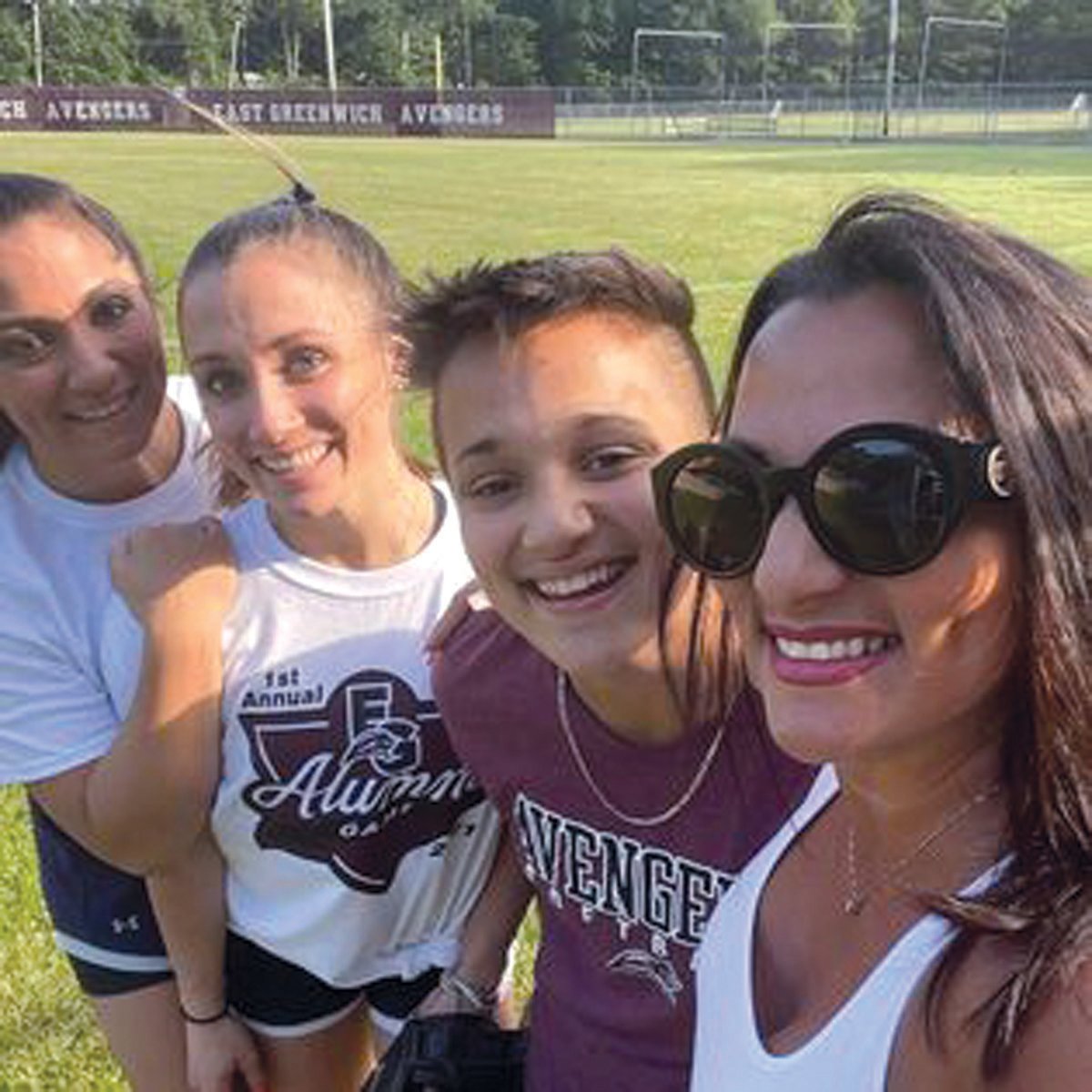 Janine Passaretti-Molloy (right), posed for a photo with her three daughters, Olivia, Victoria and Jackie Passaretti, during an alumni softball game.
